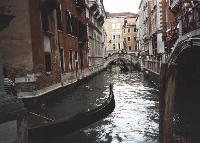 gondola on a canal, 
bridge in the distance